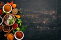 A set of spices and herbs. Indian cuisine. Pepper, salt, paprika, basil, turmeric. On a black wooden chalkboard. Royalty Free Stock Photo