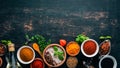A set of spices and herbs. Indian cuisine. Pepper, salt, paprika, basil, turmeric. On a black wooden chalkboard. Royalty Free Stock Photo
