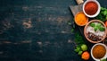 A set of spices and herbs. Indian cuisine. Pepper, salt, paprika, basil, turmeric. On a black wooden chalkboard. Royalty Free Stock Photo