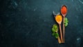 A set of spices in wooden spoons on a black background. Royalty Free Stock Photo