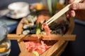 Set with spicy wasabi paste and pickled ginger on a wooden stand, top view. Maki and rolls with tuna, salmon, shrimp, crab and