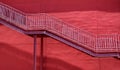 A set of stairs ascending a large red wall Royalty Free Stock Photo