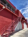 A set of stairs ascending a large red wall Royalty Free Stock Photo
