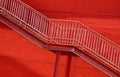 A set of stairs ascending a large red wall Royalty Free Stock Photo