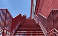 A set of stairs ascending a large red wall Royalty Free Stock Photo