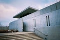 Set of stairs leading to the side of a modern cement building, with two simple chairs Royalty Free Stock Photo