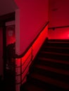 a set of stairs with red lighting in the dark room