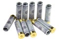 Set of standing and lying transparent plastic 12 caliber hunting shotgun shells loaded with hundred us dollars bills.