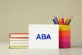 Set of stationery and card with abbreviation ABA Applied Behavior Analysis on wooden table against beige background