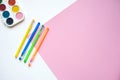 A set of stationery on a white and pink background, pens of different colors and watercolor