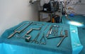 Set of steel surgical tools on blue cloth - real instruments used in mobile medical army tent, blurred operating table background Royalty Free Stock Photo