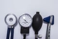 Set of stethoscope with diaphragm upwards, sphygmomanometer, air inflating bulb and neurological reflex hammer on medical table. K Royalty Free Stock Photo