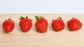 Set of strawberries on wooden and white background.