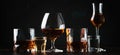 Set of strong alcoholic drinks in glasses and shot glass in assortent: vodka, rum, cognac, tequila, brandy and whiskey. Dark Royalty Free Stock Photo