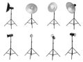 Set with studio flash lights with reflectors on tripods against white background Royalty Free Stock Photo