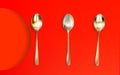 Set stylish spoons, isolated realistic gilded clean objects on red background. 3d top view tablewares and soft shadow. Vector Royalty Free Stock Photo