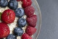 Set of summer berries with oatmeal and chia seeds in a small glass bowl on a black stone background. Perfectly healthy summer