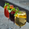 Set of summer refreshments on a stone background with copy space. three glasses of red, yellow and orange lemonade. Royalty Free Stock Photo