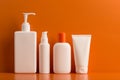 Set of sunscreen cosmetic products for skin and body care in summer against orange background.