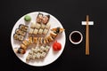 Set of sushi maki and rolls at black rustic wood. Royalty Free Stock Photo