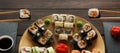 Set of sushi maki and rolls at black rustic wood. Royalty Free Stock Photo