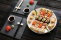 Set of sushi maki and rolls on black rustic wood Royalty Free Stock Photo