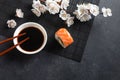 Set of sushi and maki rolls with branch of white flowers on stone table