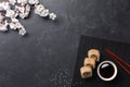 Set of sushi and maki rolls with branch of white flowers on stone table