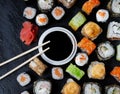 Set of sushi and maki with soy sauce and wooden sticks on stone table. Royalty Free Stock Photo