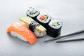 Set of Sushi nigiri with salmon and avocado, and rolls with cucumber on a gray background