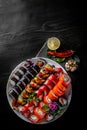 Set of sushi roll with salmon, avocado, cream cheese, cucumber, rice, caviar, eel in plate on black wooden table Royalty Free Stock Photo