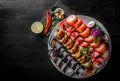 Set of sushi roll with salmon, avocado, cream cheese, cucumber, rice, caviar, eel in plate on black wooden table Royalty Free Stock Photo