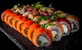 Set of sushi roll with salmon, avocado, cream cheese, cucumber, rice, caviar, eel in plate on black wooden table Royalty Free Stock Photo