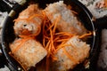 Set of sushi rolls on a black plastic platter decorated with soy sauce and spices.