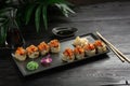 Set of sushi rolls on a black plate on a black wooden background Royalty Free Stock Photo