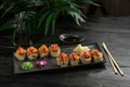 Set of sushi rolls on a black plate on a black wooden background Royalty Free Stock Photo
