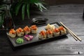 Set of sushi rolls on a black plate on a black wooden background Royalty Free Stock Photo