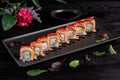 Set sushi rolls on a black rectangular plate on a dark background Royalty Free Stock Photo