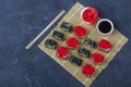 Set of sushi roll with omelet, tofu and vegetables, flying fish roe, tempura on makisu on a dark background. Traditional Japanese Royalty Free Stock Photo