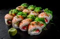 Set of Sushi rolls with seafood, srimp, cream cheese,caviar and Chuka salad on black wooden table Royalty Free Stock Photo