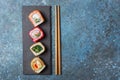 Set of sushi rolls served on a black slate board with chopsticks Royalty Free Stock Photo