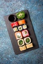 Set of sushi rolls served on a black slate board with soy sauce Royalty Free Stock Photo