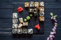 A set of sushi, sakura on a black wooden background