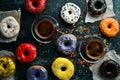 Set of sweet colored donuts with a cup of coffee on a black stone table. Royalty Free Stock Photo