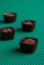 Set of sweet delicious praline brown candies on green background.
