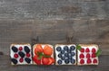 Set of sweet sandwiches with ricotta cheese and fresh forest berries over a wooden background