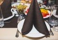 Set table with plates and dishes at the restaurant. Birthday party or wedding celebration at the cafe with different food. Black