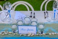 Set table for a white and aqua blue beach wedding dinner. Candles, wine glasses, shells and a Free Spirits card. Royalty Free Stock Photo