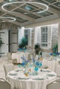 Set tables with bouquets of flowers in a restaurant with round lamps