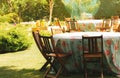 Set tables with floral tablecloths. Private backyard party. Garden furniture.